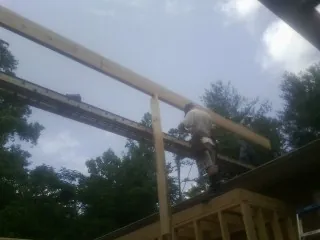 Carpenter setting a ridge beam over a new addition frame — Ice Dam Removal by Roofing Brothers in Wilder